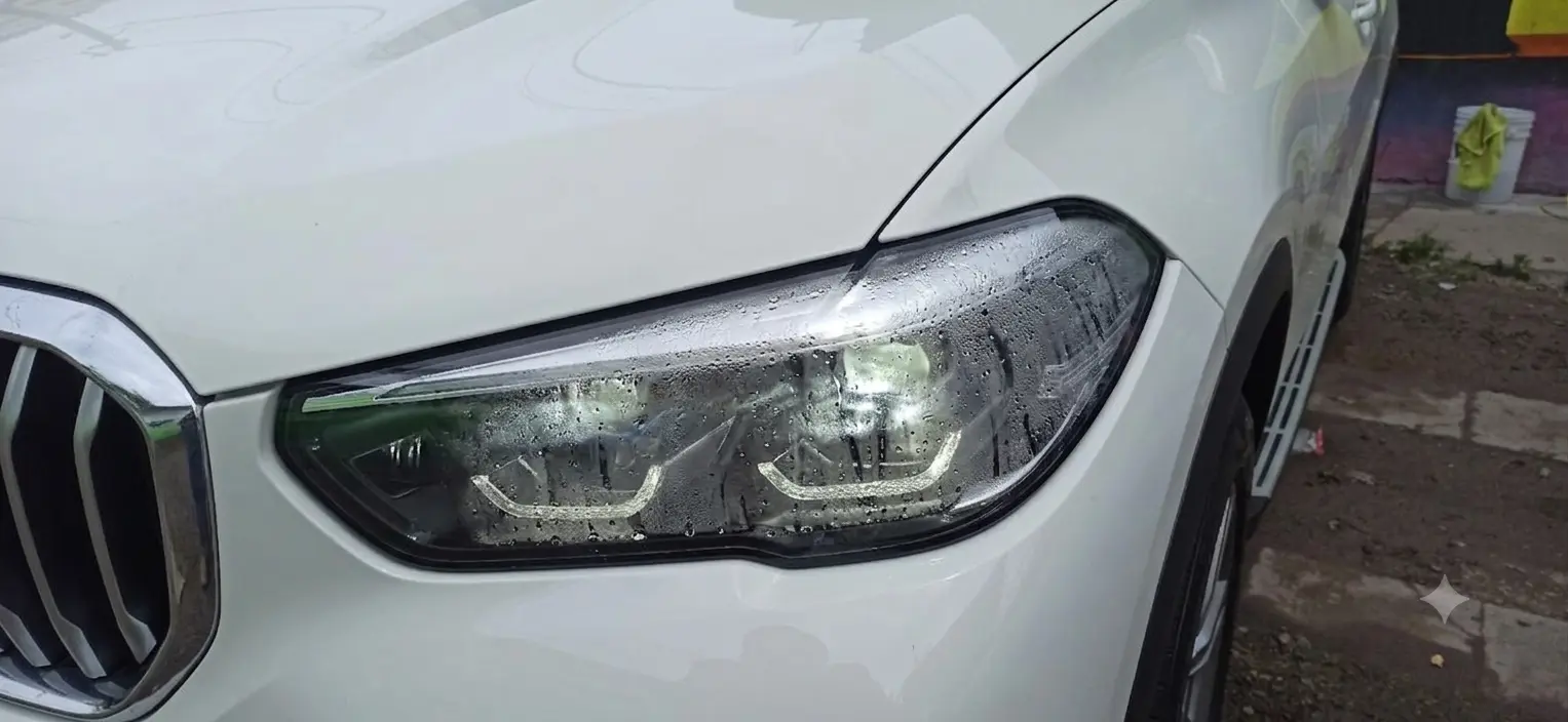 Foco de BMW con humedad interna antes del servicio profesional - Hustla Garage